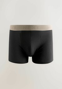Boxer breif neri con design aderente, realizzati in tessuto morbido. Presentano un elastico tono beige chiaro con il logo "NEXT" in delicata impressione.