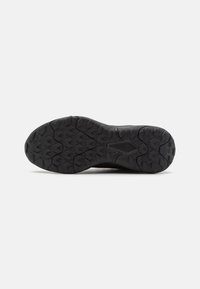Black shoe sole with a textured grip pattern. Features deep treads and a rounded toe, designed for traction on various surfaces.