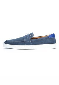 Zapato azul de ante sin cordones con una suela de goma blanca. Presenta un detalle de costura y un acento azul en el talón. Diseño minimalista.