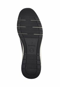 Sole of a shoe, featuring a black rubber bottom with textured grooves and white accents, branded with "tamaris" and size 37.