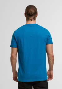 Blaues Kurzarm-T-Shirt aus weichem Baumwollstoff, mit Rundhalsausschnitt und leicht strukturiertem Stoff. Die Rückseite zeigt ein glattes, ungeschmücktes Design.