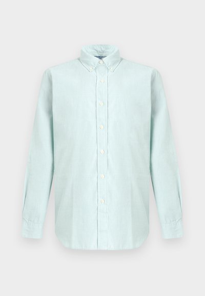 Lyseblå langermet skjorte med knapper, knapp-ned-krage, hvite knapper og buet kant på nøytral bakgrunn.