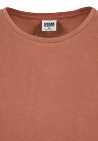 T-shirt marron en coton à col rond avec une étiquette visible de taille XS de la marque Urban Classics cousue à l'intérieur du col.