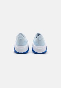 Chaussures de sport bleu clair avec un dessus texturé, une semelle intermédiaire blanche et une semelle extérieure bleue, dotées d'un col rembourré et d'une languette au talon.