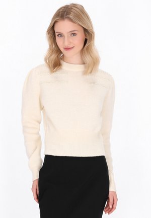 Maglione color crema con orlo e polsini a coste. Caratterizzato da dettagli testurizzati di piccoli perline sulle spalle e una silhouette aderente.