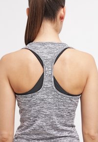 Débardeur athlétique gris avec un motif texturé, doté d'un dos nageur et de détails noirs aux épaules et à l'encolure.