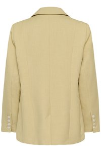 Μπεζ ραμμένο σακάκι με γιακά με εγκοπή, μακριά μανίκια και τέσσερα λευκά κουμπιά σε κάθε μανσέτα, εμφανιζόμενο από πίσω.