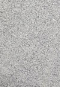 Tessuto di felpa grigio chiaro con una finitura morbida e testurizzata. Presenta un bordo e polsini a coste, con un motivo melangiato sottile.