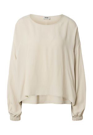 Blusa beige de manga larga con escote redondo, ajuste suelto y puños elásticos, con un dobladillo trasero ligeramente más largo.