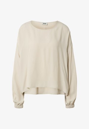 Blusa beige de manga larga con escote redondo, ajuste suelto y puños elásticos, con un dobladillo trasero ligeramente más largo.