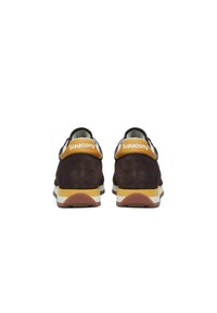 Sneaker in suede marrone con accenti gialli sul tallone, suola intermedia bianca, suola in gomma e logo del marchio sul retro. Lacci piatti e collare imbottito.