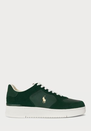 Green suede and leather sneakers with white rubber sole, lace-up design, and gold logo accent on the side. Features rounded toe and perforations.