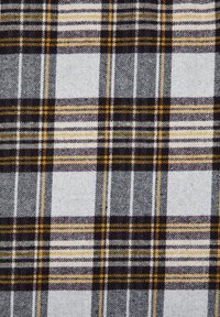 Motif en tissu à carreaux avec des lignes croisées noires, blanches, grises et jaunes formant des carrés.