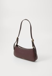 Bolso de hombro de cuero burdeos con un diseño curvado, strap ajustable y acentos en dorado. Presenta una textura suave y un branding mínimo.