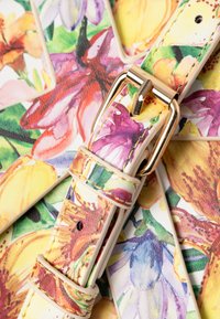 Uhrband mit floralem Muster in einem mehrfarbigen Design und goldfarbenen Elementen. Hergestellt aus Leder mit einer glatten, polierten Textur.