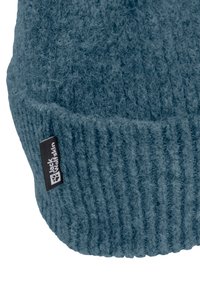 Berretto blu lavorato a maglia con texture a coste. Presenta un'etichetta nera con logo bianco. Materiale morbido adatto per il freddo.