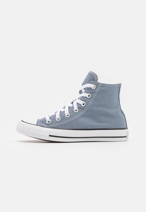Baskets montantes en toile bleu clair avec lacets blancs et semelle en caoutchouc, vues de côté sur un fond blanc uni.
