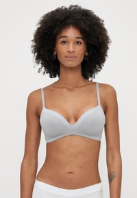 Szara biustonosz z gładką fakturą, głębokim dekoltem i regulowanymi ramiączkami. Opcja bezszwowa o minimalistycznym stylu.