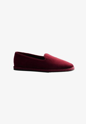Chaussure à enfiler bordeaux avec une texture douce en daim et une semelle noire basse, conçue pour un usage intérieur ou extérieur léger.
