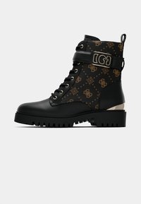 Bottines noires à la cheville avec un dessus texturé et à motifs, agrémenté d'accents dorés. Design à lacets avec une semelle robuste et résistante.