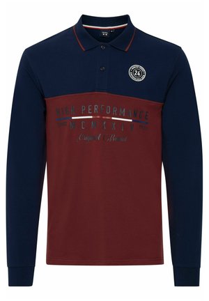 Poloko s dlhým rukávom v námorníckej modrej a burgundskej farbe s farebne rozdeleným dizajnom, s okrúhlym logom a potlačeným textom v kontrastných farbách.