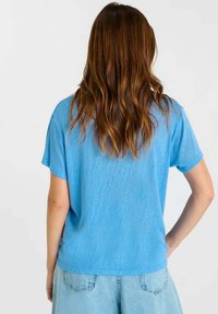 Lichtblauw shirt met korte mouwen, gemaakt van zachte stof, met een ontspannen pasvorm en een gladde textuur, voorzien van een ronde halslijn en een rechte zoom.