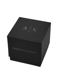 Scatola quadrata nera con finitura opaca. Testo in argento: "A/X" sopra e "ARMANI EXCHANGE" di lato. Design semplice e moderno.