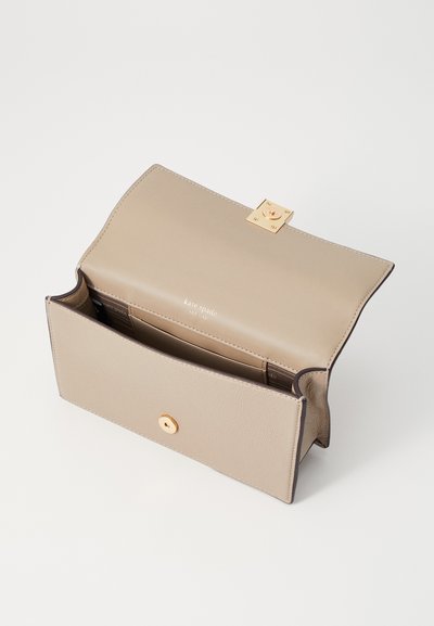 Beige leather wallet with a textured surface, gold hardware closure, and multiple card slots inside. Clean, modern design with minimal embellishments.