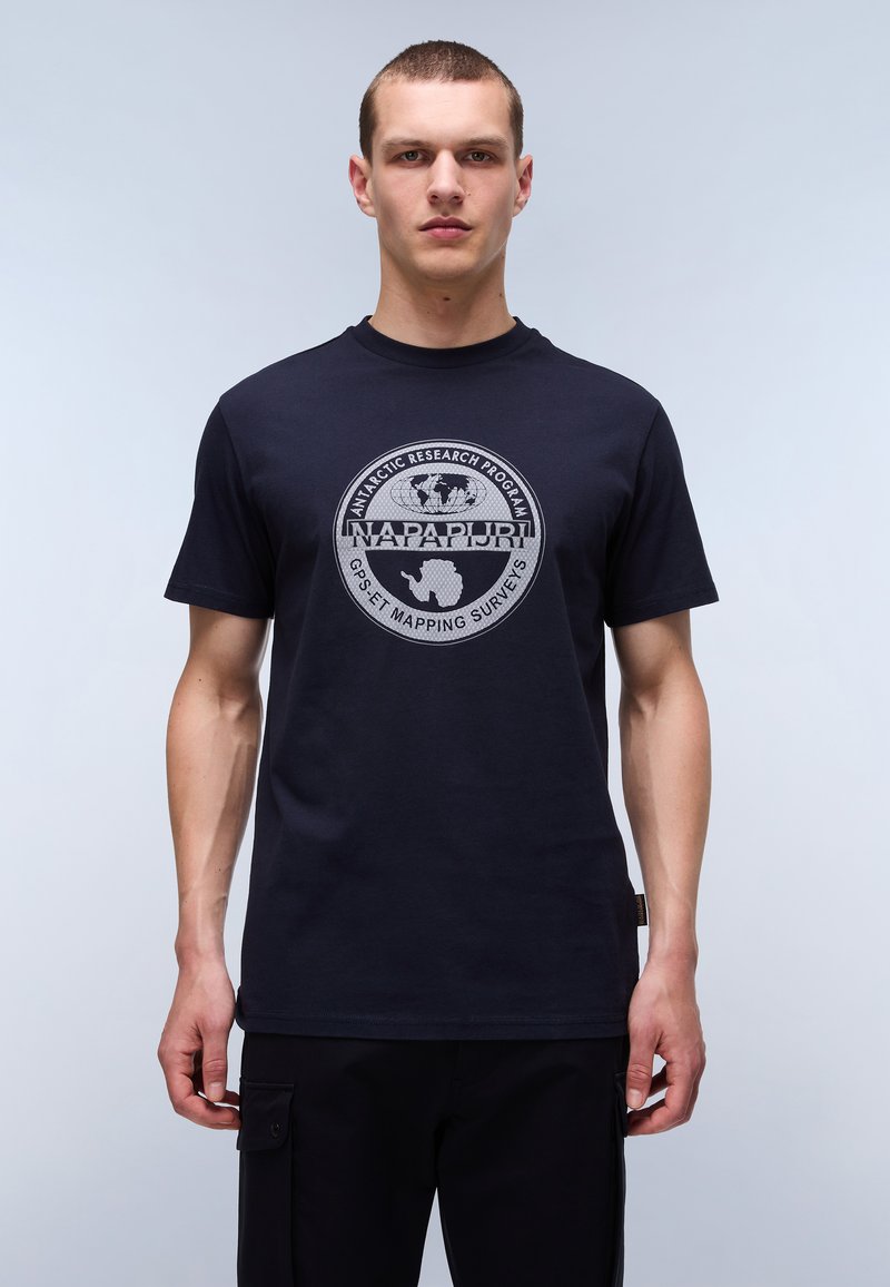 Námořnická modrá bavlněná tričko s kruhovou šedou grafikou, která obsahuje text a obrys Antarktidy. Krátké rukávy a kulatý výstřih.