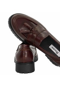 Brown leather loafers with a smooth finish, featuring tassel accents, a rounded toe, and a textured black rubber sole.