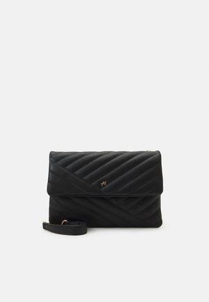 Schwarze gesteppte Clutch mit diagonaler Steppung, Klappenverschluss, kleinem goldfarbenem Logo und abnehmbarem Handriemen vor weißem Hintergrund.