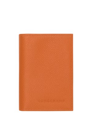 Orange textured leather wallet with visible stitching and embossed "Longchamp" branding on the lower front center.