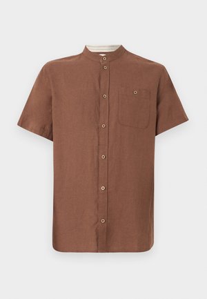 Chemise marron à manches courtes avec col mandarin, boutons sur le devant et poche poitrine avec détail bouton, présentée sur un fond uni.