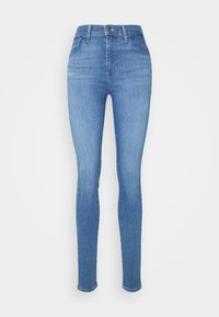Jeans ajustados de denim azul claro. Cuentan con una cintura alta, cinco bolsillos y un cierre de cremallera, con una textura limpia y suave y un diseño minimalista.