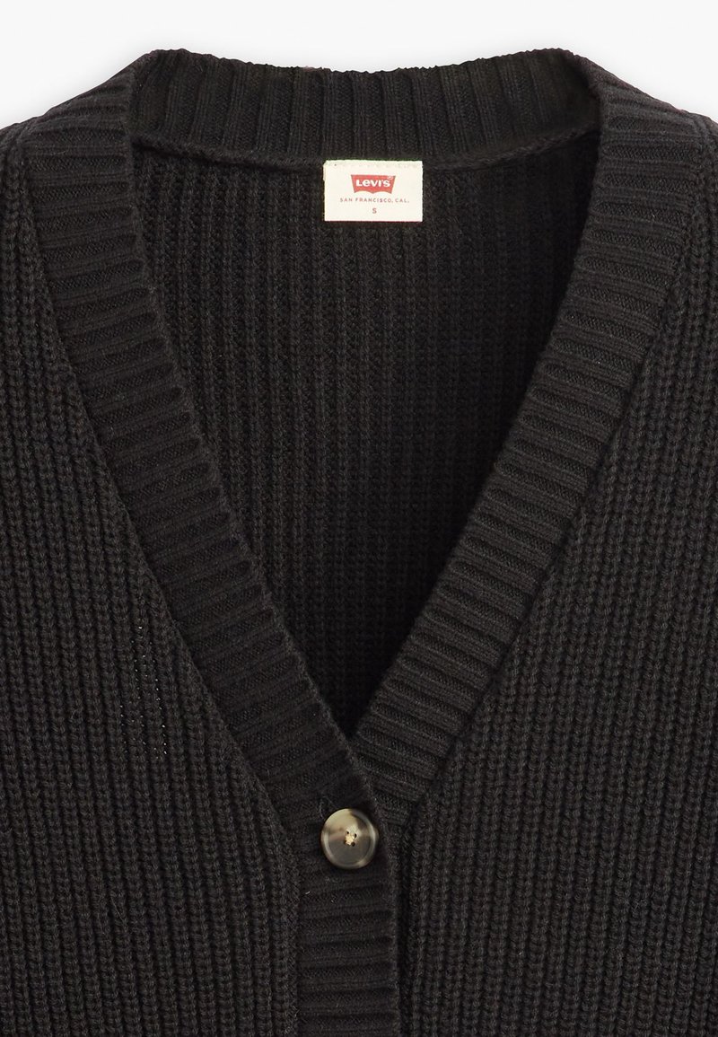 Cardigan en tricot noir avec un design en V, texture côtelée et fermeture à bouton unique. Étiquette indique "Levi's", taille S.