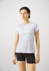 Heled lavendel sport T-särk lühikeste varrukatega ja prinditud loosungiga. Kombineeritud mustade lühikesed püksid, millel on sobiv disain ja sile tekstuur.