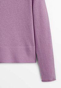 Violetti neulepusero, jossa on ribbireunat helman ja hihansuiden kohdalla. Kangas on sileä ja siinä on hieman löysä istuvuus.