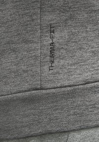 Šedá mikina s textúrovaným povrchom, s výšivkou loga "THERMAL-FIT" v tmavšej šedej na boku. Priliehavý strih s hladkým lemom.