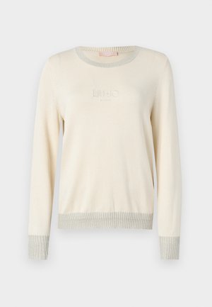 Maglione crema chiaro con maniche lunghe, polsini e orlo a coste. Presenta un logo testurizzato al centro e un collo arrotondato.