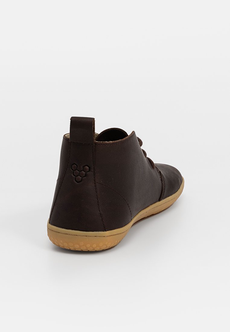 Bottines en cuir marron foncé avec une texture lisse, bout arrondi et semelle en caoutchouc beige. Présente un petit logo au niveau du talon.