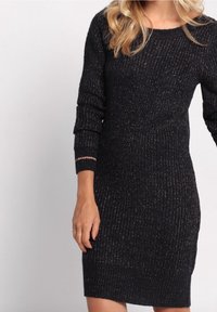 Robe pull en maille de couleur bleu marine foncé avec des fils métallisés, col rond et manches longues. Motif texturé avec des poignets et un ourlet à côtes.