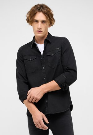 Melnā džinsa krekls ar garām piedurknēm, pogu aizdari un divām krūšu kabatām. Mīksta tekstūra, nedaudz izbalējis dizains un pielāgota piegriezuma forma.