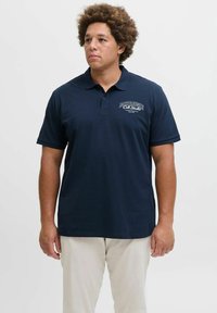 Marineblaues Baumwollpolohemd mit Kragen, kurzen Ärmeln und einem Logo auf der Brust. Es hat ein einfarbiges Design und eine lockere Passform.