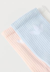 Ριμπ πλεκτές κάλτσες σε ανοιχτό ροζ, μωβ ομπλε και λευκό χρώμα· διαθέτουν διακριτικό σχέδιο με πουλιά· απαλό, πλεκτό ύφασμα που αυξάνει την άνεση.