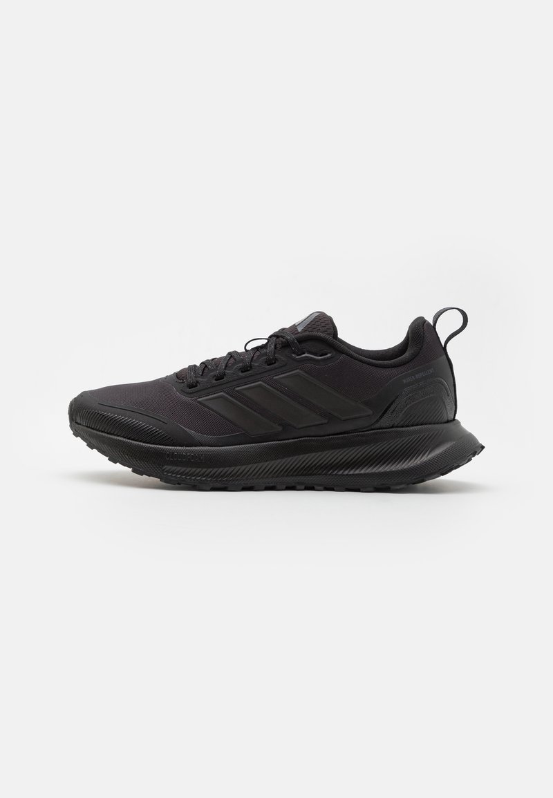 Black athletic shoe featuring a textured upper, three stripes on the side, and a rubber sole with a patterned tread for traction.