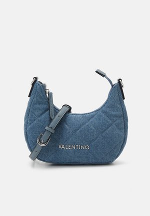 Blauwe gewatteerde denim Valentino schoudertas met verstelbare band en zilveren logo aan de voorkant tegen een effen achtergrond.