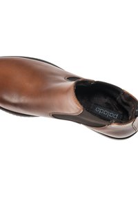 Zapato marrón de cuero sin cordones con acentos elásticos a los lados; textura suave y puntera redondeada; el interior cuenta con forro de tela negra y logo.