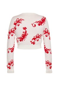 Motivo floreale rosso su un maglione corto bianco, con maniche lunghe e scollatura rotonda, realizzato in tessuto lavorato a maglia con una superficie liscia.