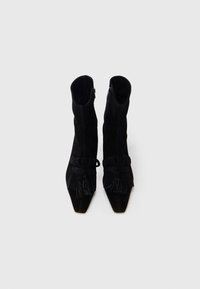 Μαύρα σουέτ μποτάκια αστραγάλου με μυτερή μύτη, διακοσμητικό κρόσσι και πλαϊνό φερμουάρ. Λείο υλικό και εφαρμοστή σχεδίαση.