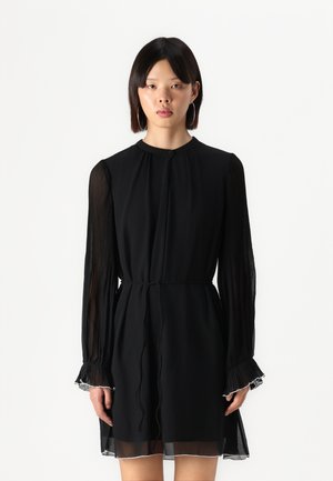 Black dress with pleated long sleeves, a fitted waist, and sheer hem. Features a high collar and delicate detailing at sleeve cuffs.